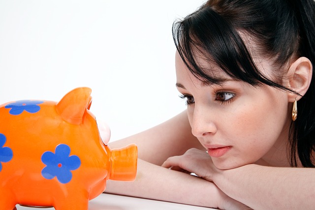 Dependent on little hidden saving Girl staring at piggybank